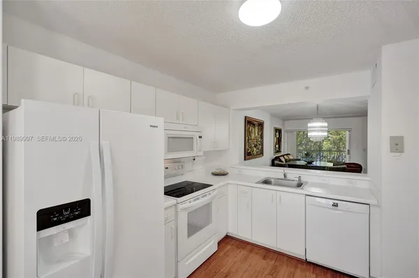a kitchen with white cabinets and white appliances
