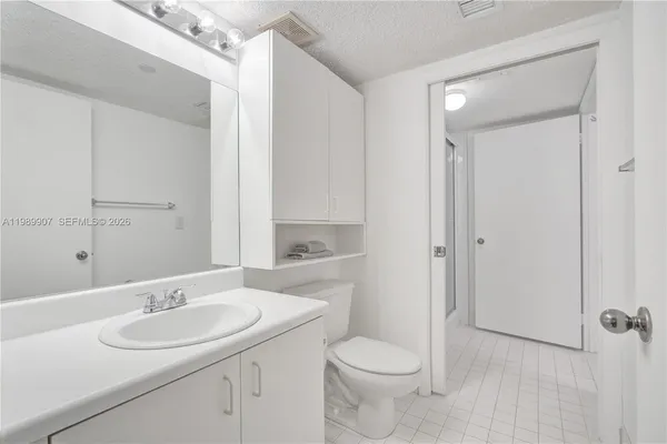 a bathroom with a sink toilet a mirror and shower