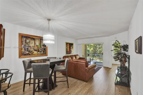 a living room with furniture a potted plant and a large window