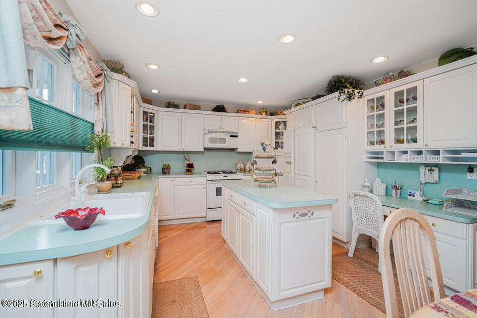 312 Barbara Street Staten Island, NY 10306 - Photo 11 of 34 a kitchen with a sink a stove cabinets and a window