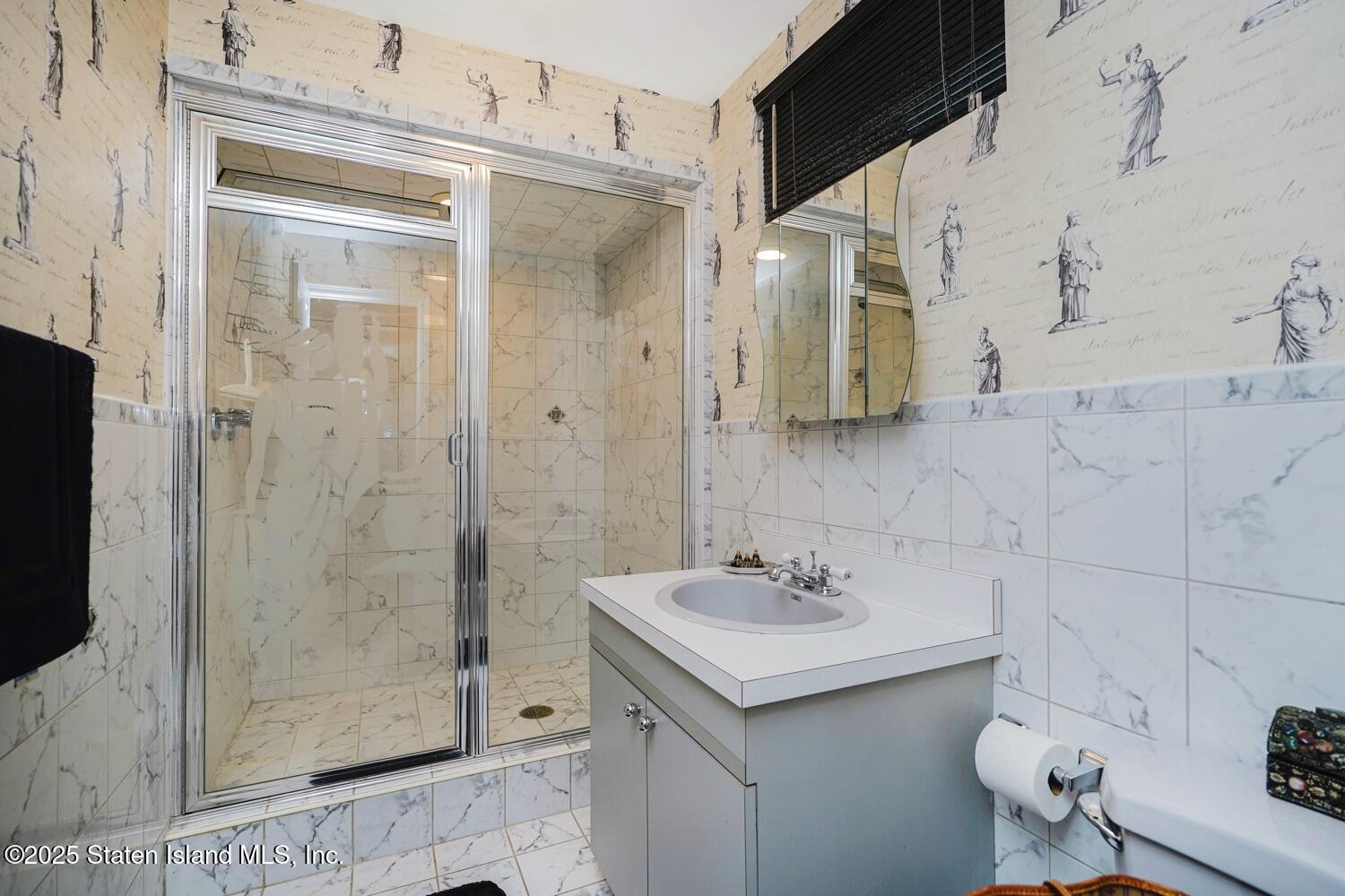 312 Barbara Street Staten Island, NY 10306 - Photo 23 of 34 a bathroom with a shower sink and mirror