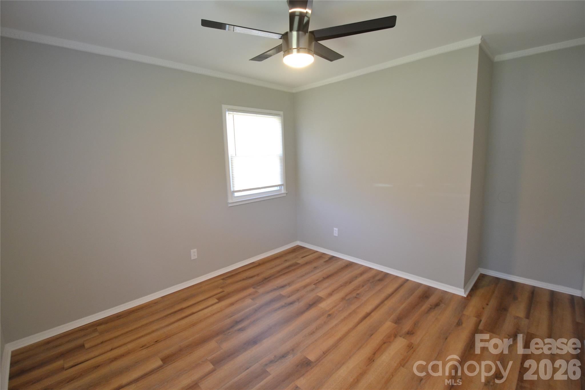 1422 Thermal Road Charlotte, NC 28212 - Photo 32 of 40 an empty room with wooden floor ceiling fan and windows