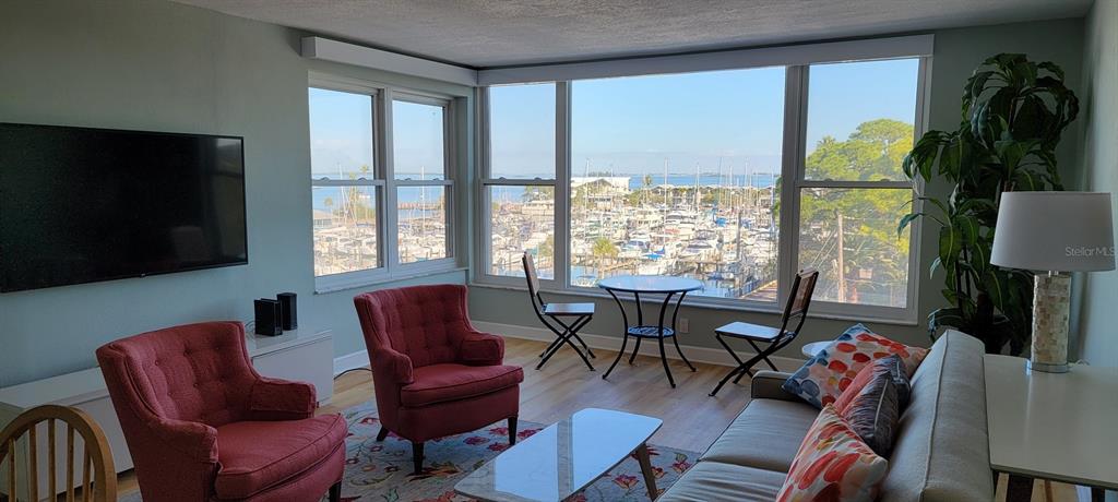 632 Edgewater Drive, Unit 537 Dunedin, FL 34698 - Photo 12 of 28 a living room with furniture a flat screen tv and a large window