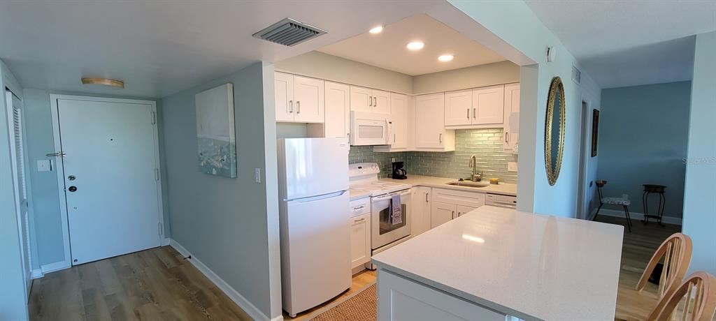 632 Edgewater Drive, Unit 537 Dunedin, FL 34698 - Photo 14 of 28 a kitchen with stainless steel appliances a refrigerator stove microwave and cabinets