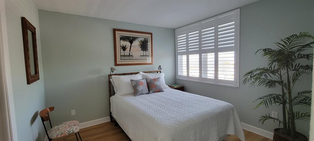 632 Edgewater Drive, Unit 537 Dunedin, FL 34698 - Photo 20 of 28 a bedroom with a bed and a potted plant next to a window