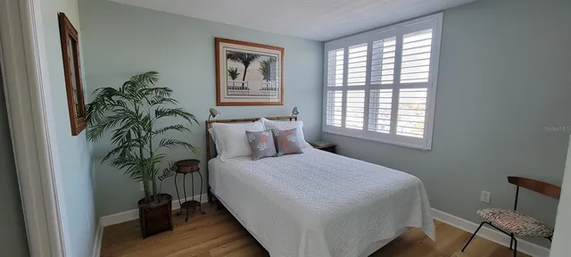 a bedroom with a bed table closet and a window