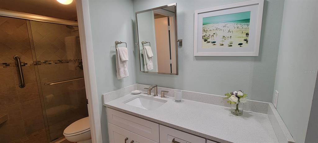 632 Edgewater Drive, Unit 537 Dunedin, FL 34698 - Photo 10 of 28 a bathroom with a granite countertop sink toilet and a mirror