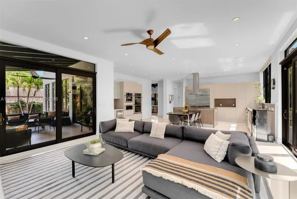a living room with furniture a flat screen tv and a large window