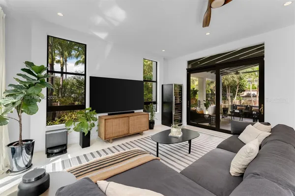 a living room with patio furniture and a potted plants