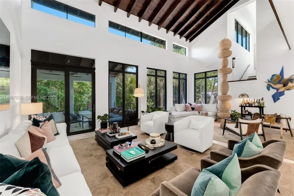 a living room with furniture fireplace and large windows