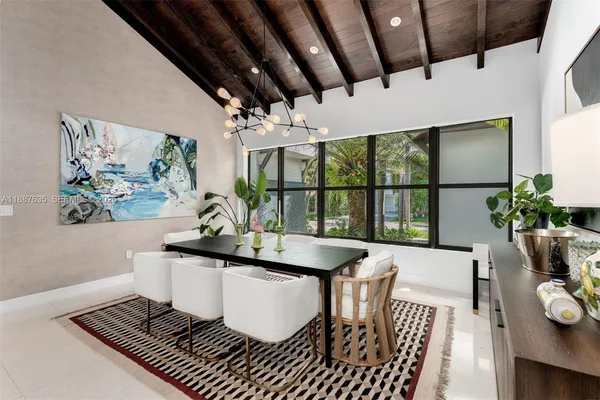 a dining room with furniture a rug and a potted plant