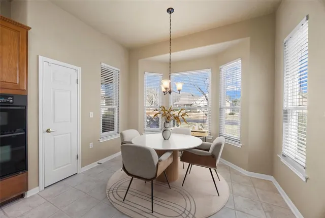 a view of a livingroom with a fireplace a chandelier and a kitchen
