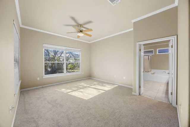 a spacious bedroom with a bed and a chandelier