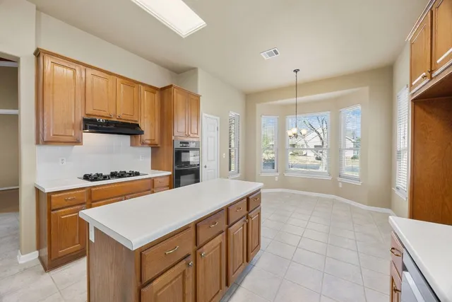 a kitchen with stainless steel appliances a stove sink and cabinets