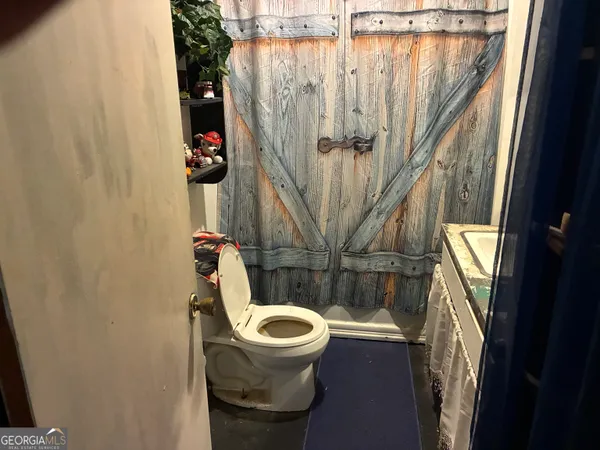 a bathroom with a toilet and a shower curtain
