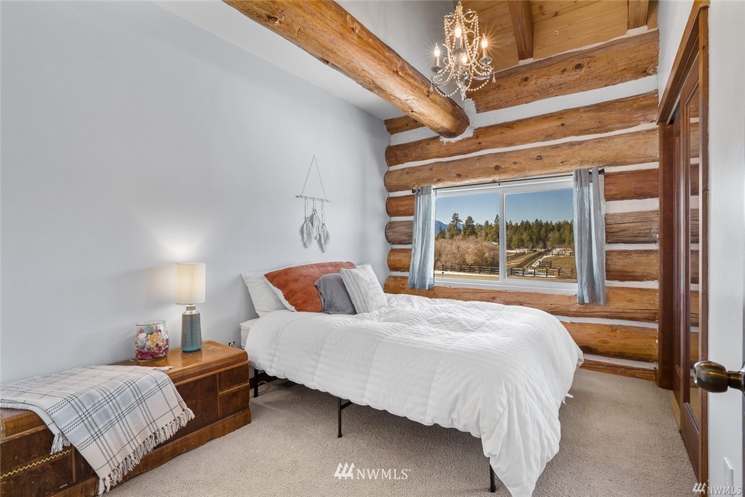 170 Quail Valley Road Cle Elum, WA 98922 - Photo 20 of 40 a bedroom with a bed and a chandelier