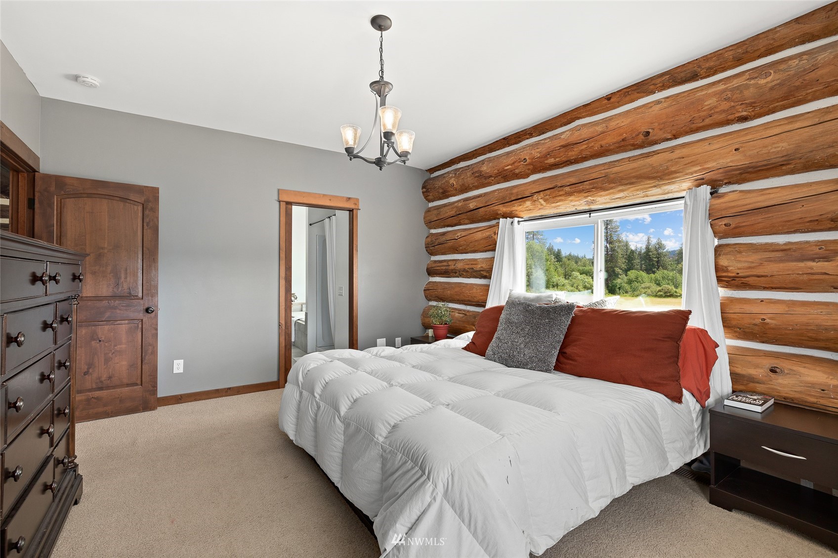 170 Quail Valley Road Cle Elum, WA 98922 - Photo 24 of 40 a bedroom with a large bed and a chandelier