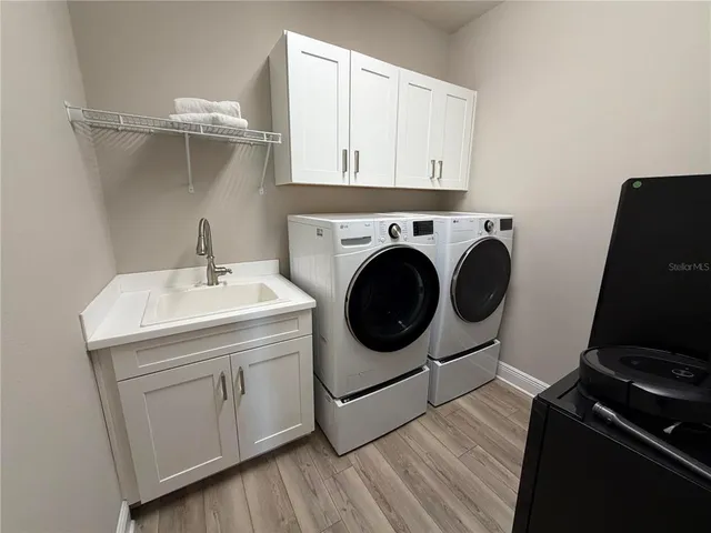 a utility room with sink dryer and washer