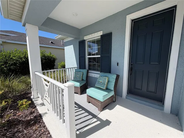 a view of a porch with wooden floor and outdoor seating