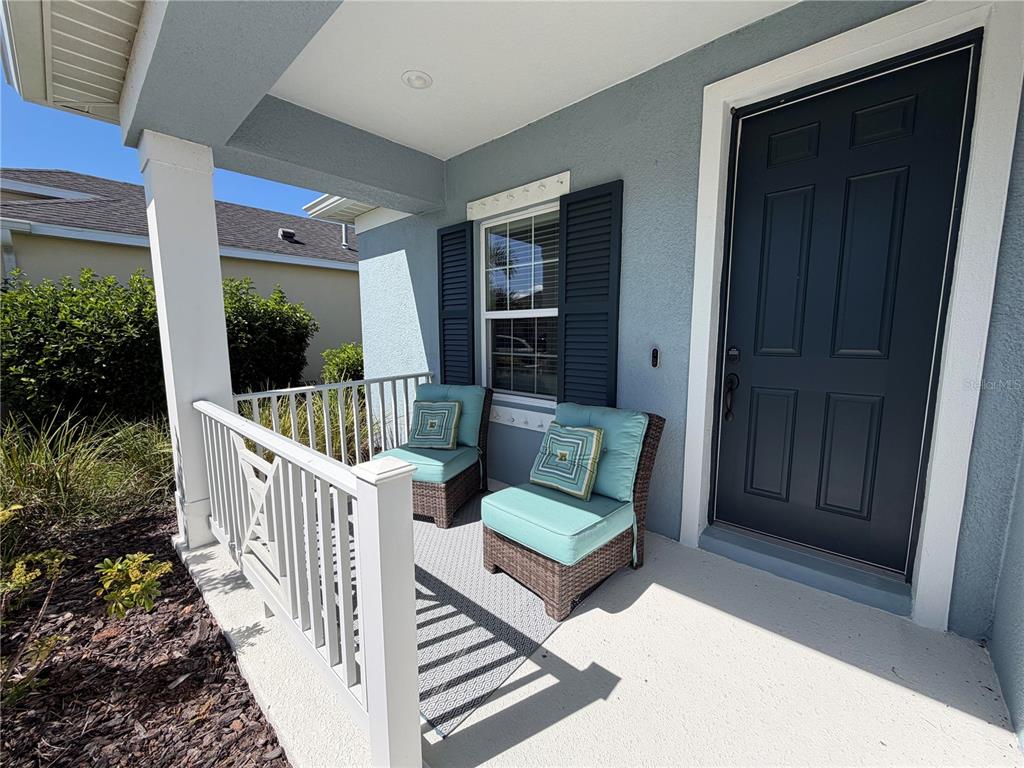 10710 Falling Leaf Court Parrish, FL 34219 - Photo 2 of 28 a view of a porch with wooden floor and outdoor seating