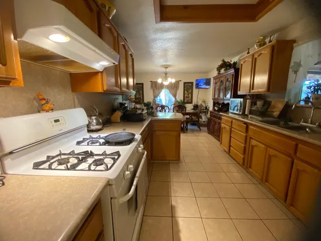 a kitchen with a sink a stove and lots of cabinets