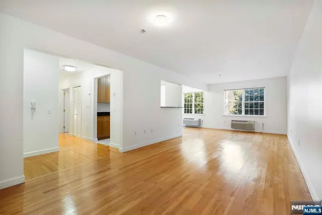 a view of a big room with wooden floor and windows