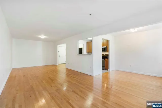 a view of a kitchen with wooden floor and a refrigerator