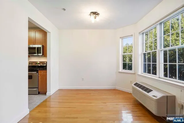 a view of a kitchen with kitchen island a sink wooden floor and a large window