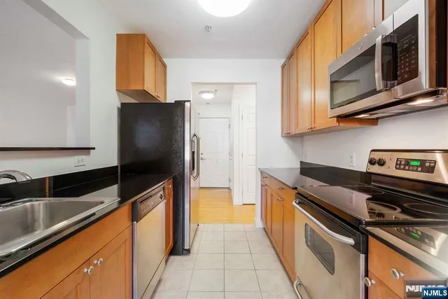 a kitchen with stainless steel appliances granite countertop a refrigerator and a stove top oven