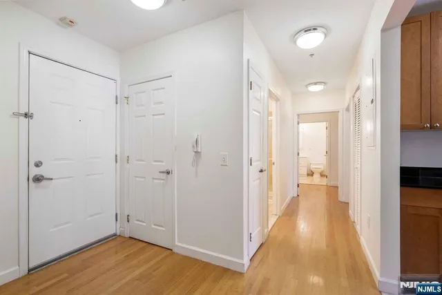 a view of a hallway with wooden floor and closet area