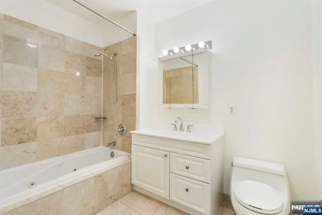 a bathroom with a toilet a sink a tub and mirror