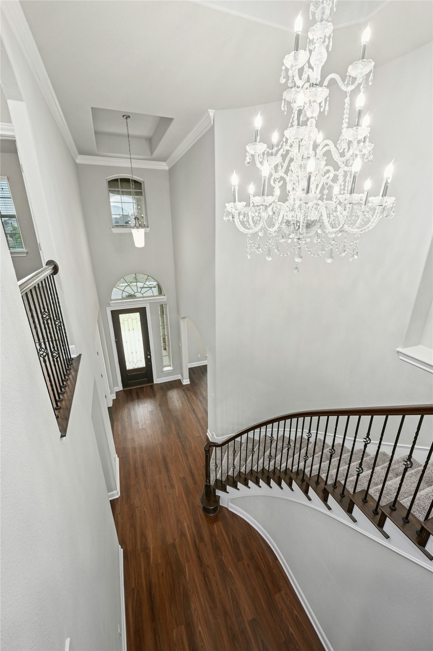 4124 Florentine Road Leander, TX 78641 - Photo 11 of 37 Foyer entrance with crown molding, dark hardwood / wood-style flooring, a raised ceiling, and a notable chandelier
