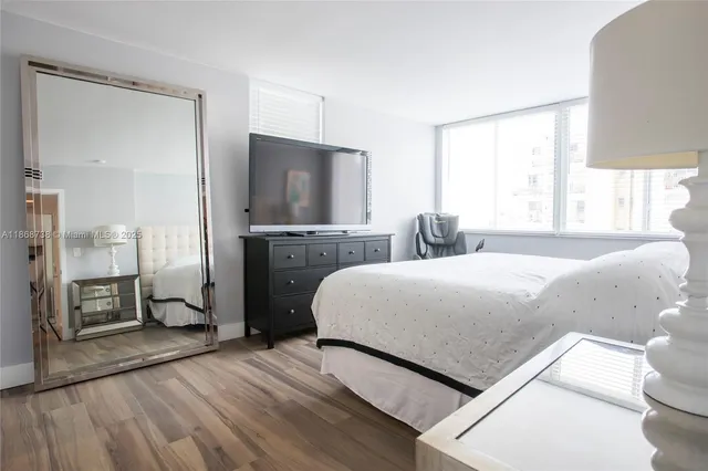 a bedroom with a bed and a flat screen tv