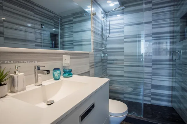 a bathroom with a sink a toilet and shower