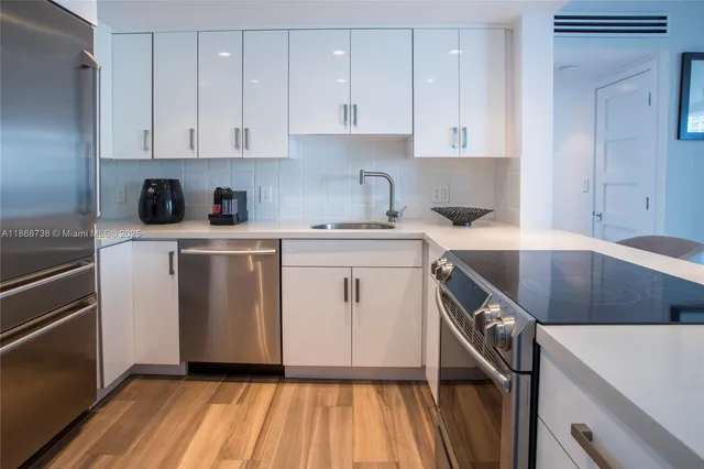 a kitchen with a white cabinets sink and white stainless steel appliances