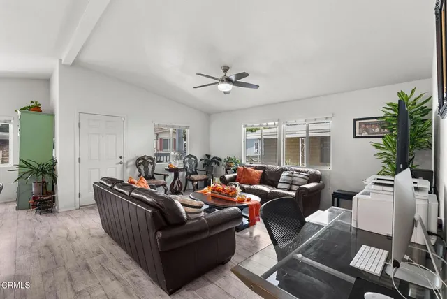a living room with furniture ceiling fan and a window