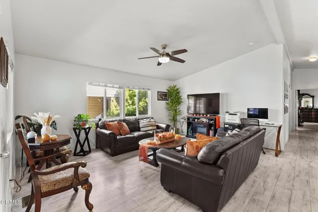 a living room with furniture ceiling fan and a window
