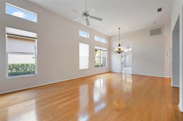 a view of an empty room with window and wooden floor