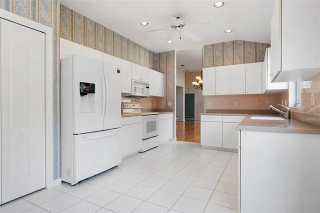 a kitchen with white cabinets and white appliances