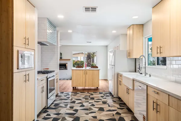 a large kitchen with a large window and stainless steel appliances