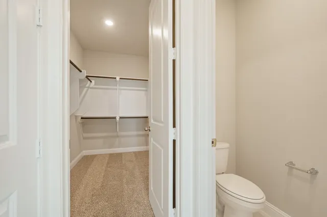 a bathroom with a glass door shower and a toilet