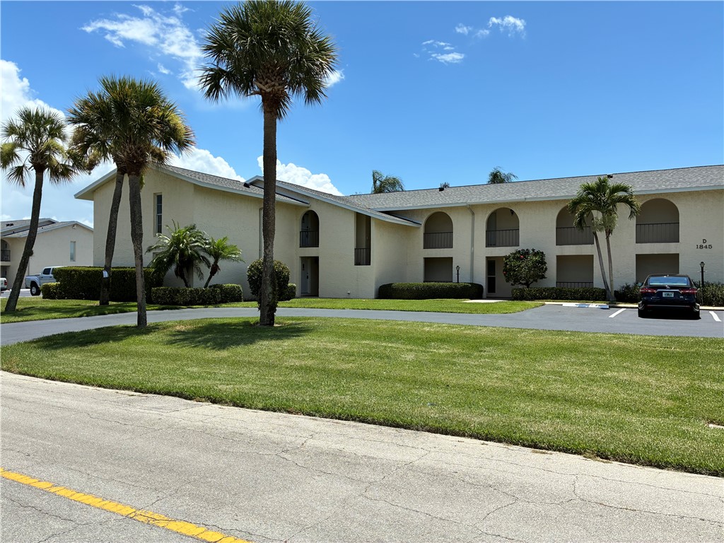 1845 Robalo Drive, Unit 201D Vero Beach, FL 32960 - Photo 24 of 35 a front view of a house with garden and trees