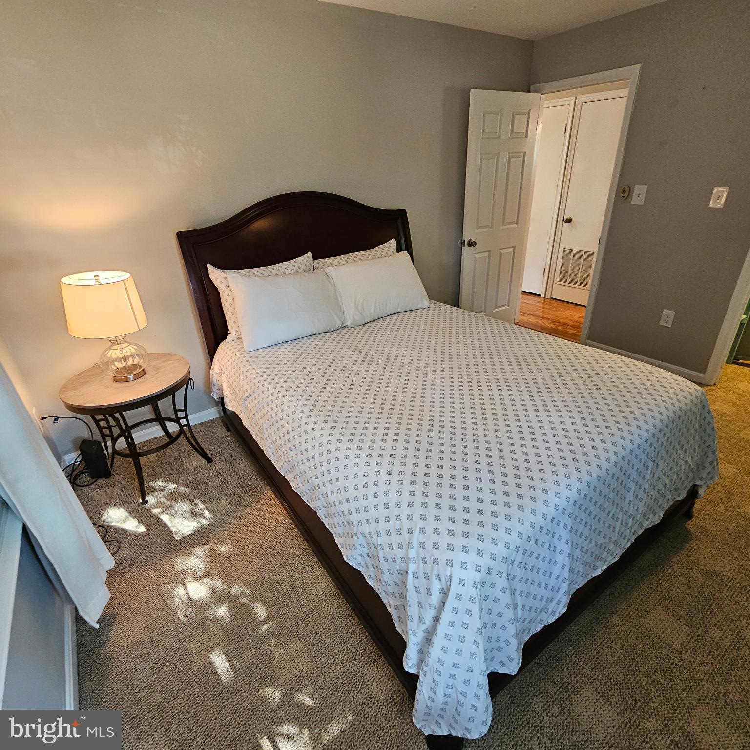 8637 D Beekman Place, Unit 37D Alexandria, VA 22309 - Photo 11 of 18 a bed sitting in a bedroom next to a lamp