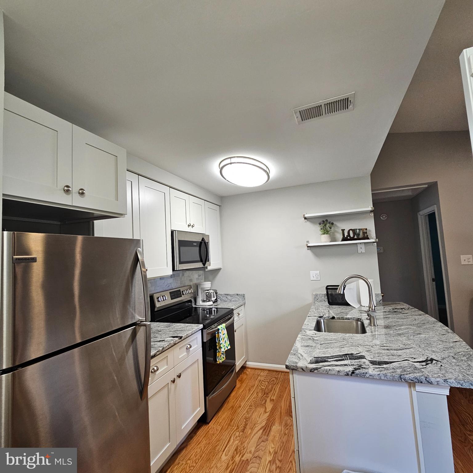 8637 D Beekman Place, Unit 37D Alexandria, VA 22309 - Photo 7 of 18 a kitchen with refrigerator a stove and a sink
