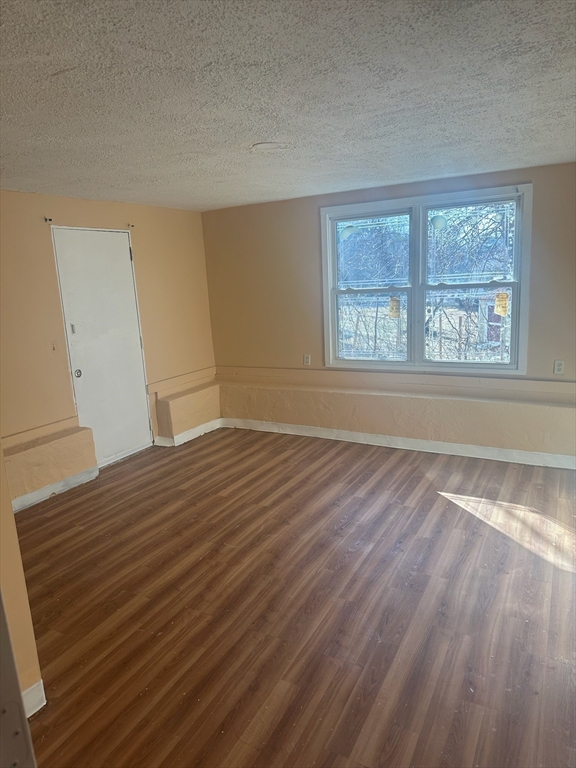 4 Gallagher Drive, Unit 1 Randolph, MA 02368 - Photo 6 of 9 wooden floor in an empty room with a window