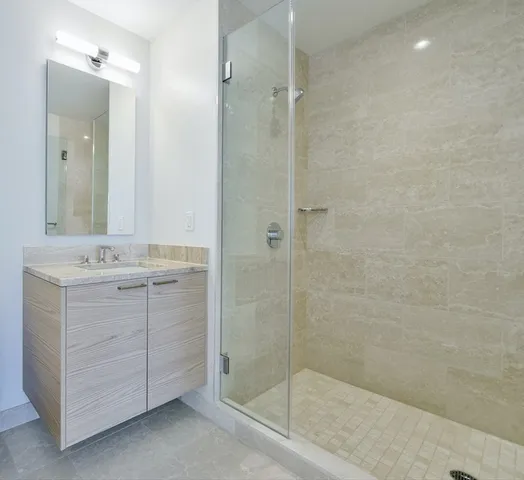 a bathroom with a shower sink and mirror