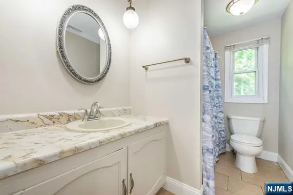 a bathroom with a granite countertop sink a toilet and a mirror
