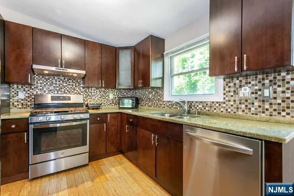 a kitchen with granite countertop cabinets stainless steel appliances and a sink