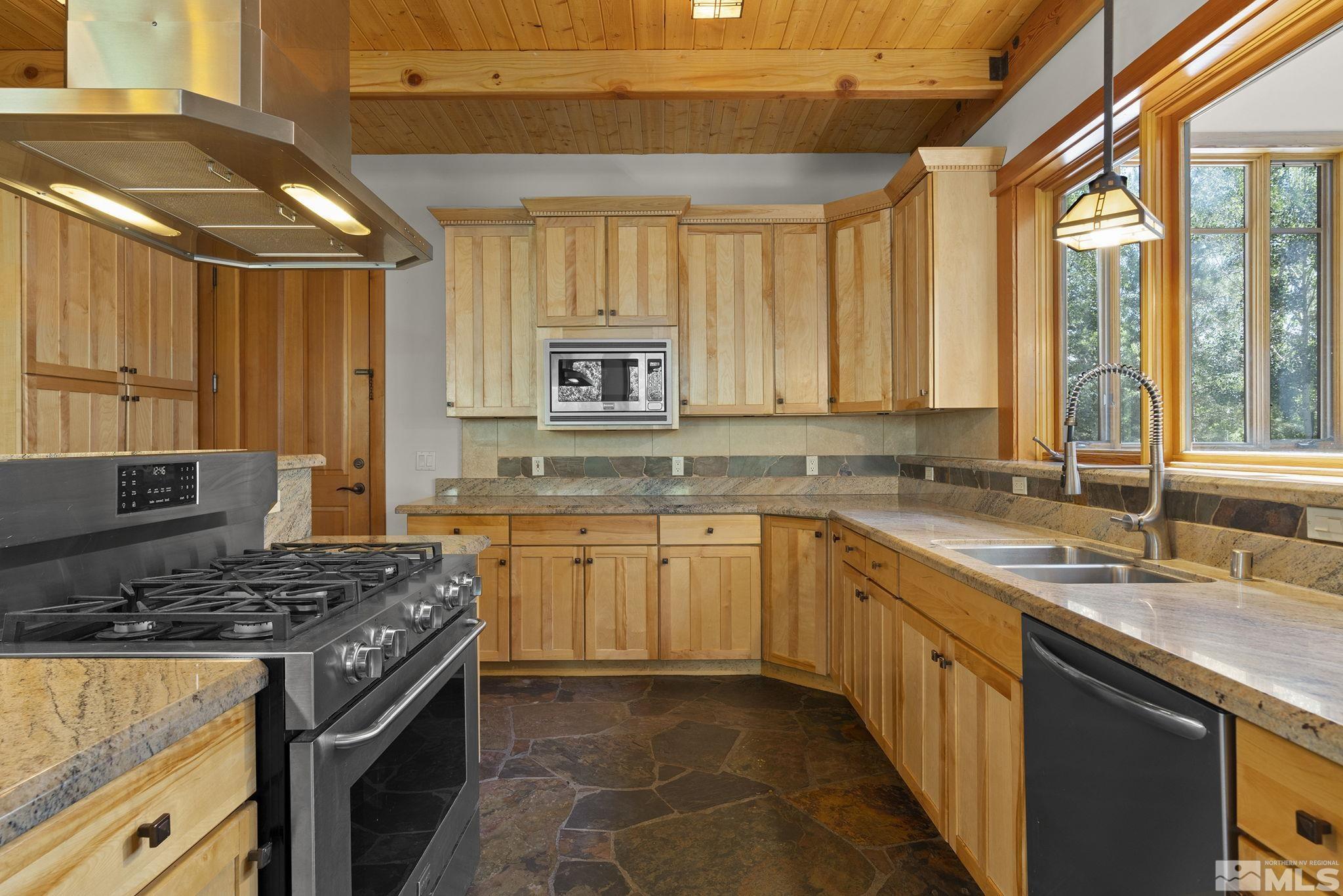 7035 Quail Rock Lane Reno, NV 89511 - Photo 12 of 37 a kitchen with stainless steel appliances granite countertop a stove a sink and a microwave