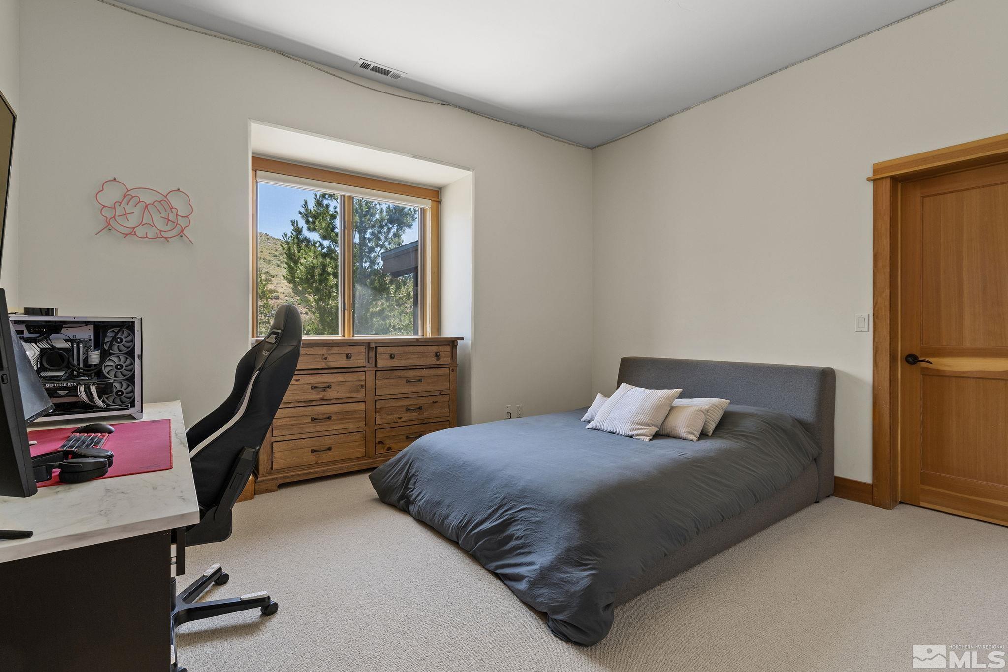 7035 Quail Rock Lane Reno, NV 89511 - Photo 22 of 37 a bedroom with a bed a window and dresser